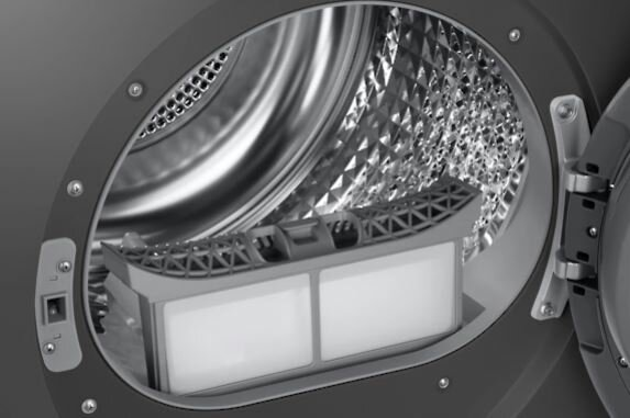 W bębnie pralki widoczna jest przegroda filtra z dwoma białymi wkładami filtra.