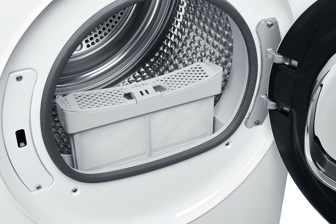 Otwarte drzwi pralki z widoczną wewnątrz przegrodą filtra. Wnętrze jest metaliczne i czyste.
