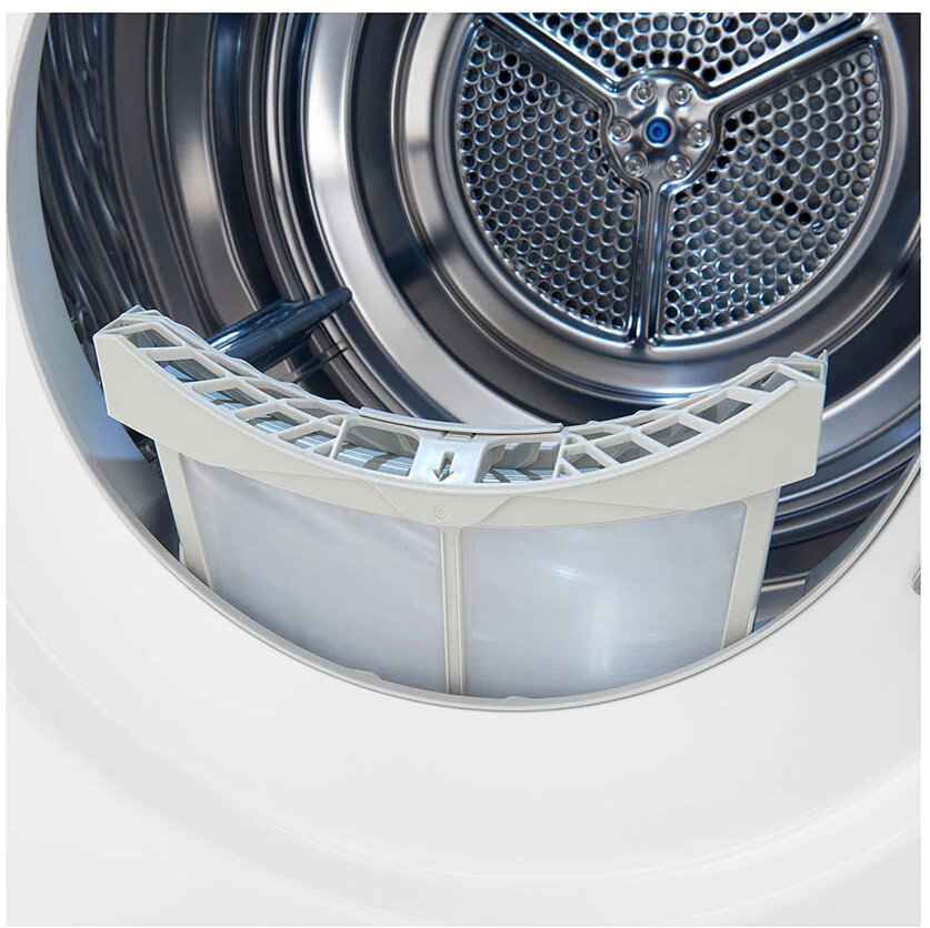 Zbliżenie białego bębna suszarki z filtrem na pierwszym planie, pokazujące wnętrze.