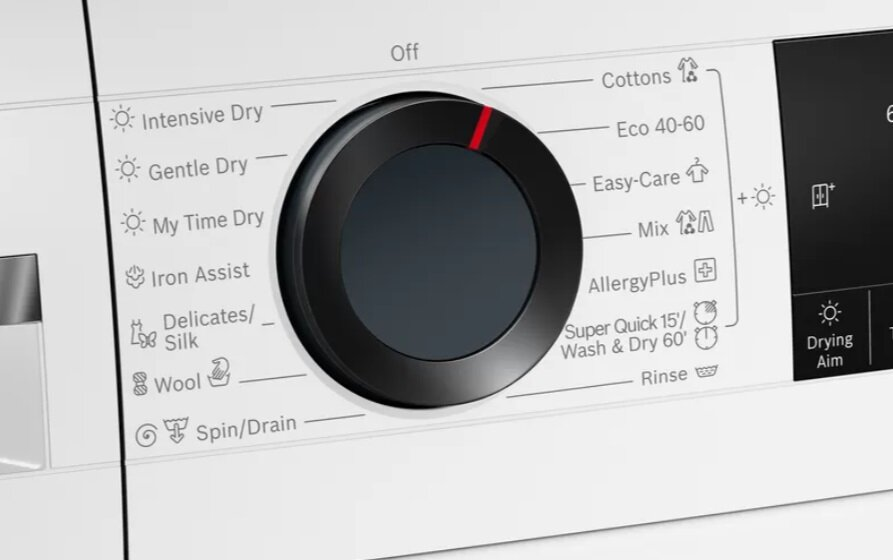 Zbliżenie panelu sterowania pralki z czarnym pokrętłem i białym tekstem ustawień.