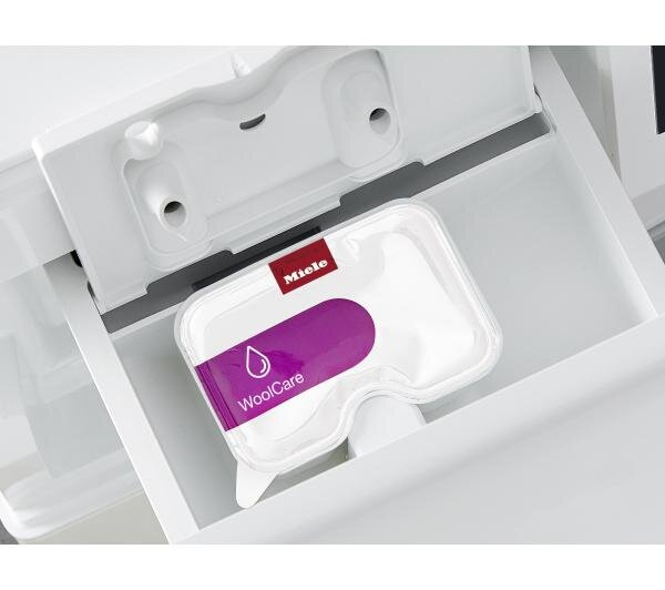 Biała szuflada pralki z opakowaniem produktu Miele WoolCare w środku.