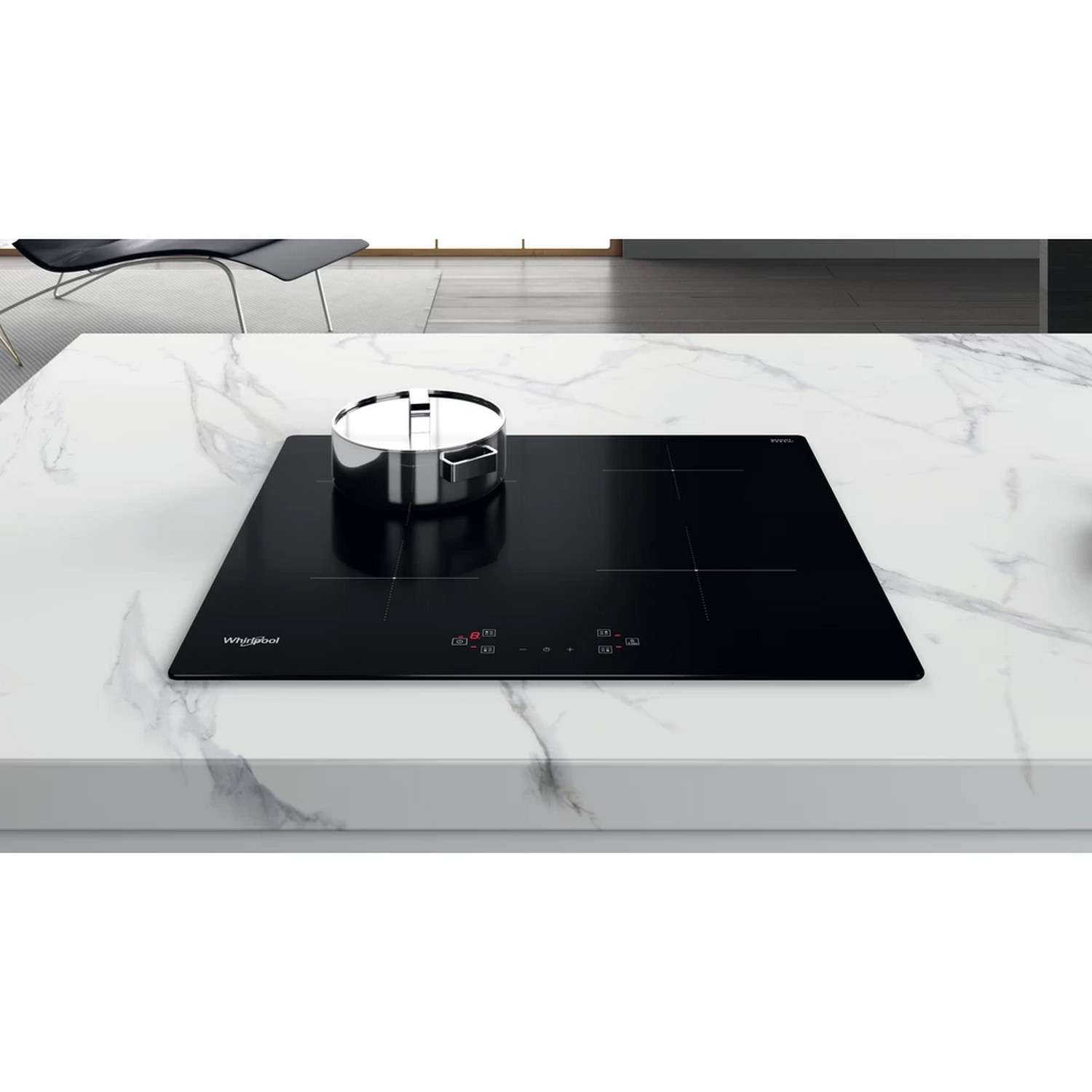 Black induction cooktop on marble countertop. Silver pot.