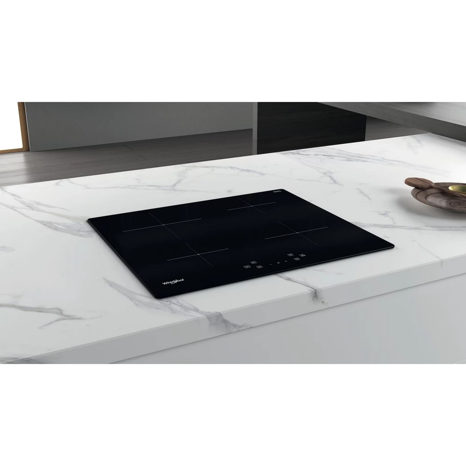 A black induction cooktop on a marble countertop. It has touch controls.