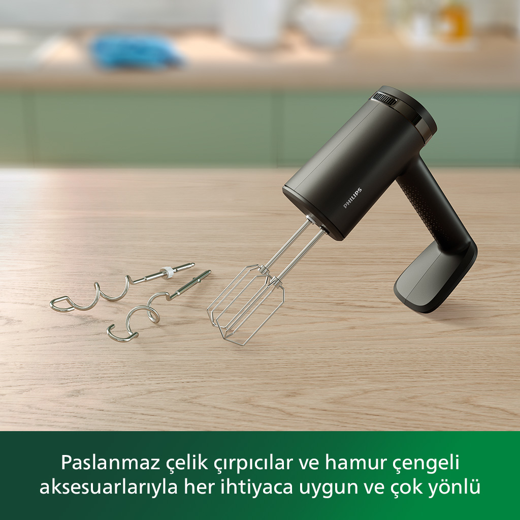 Ahşap yüzeyde siyah el mikseri ve aksesuarlar. Hamur kancaları ve çırpıcılar içerir.
