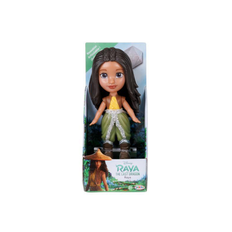 Puppe in Verpackung. Braune Haare, grünes Kleid. Hintergrund weiß.