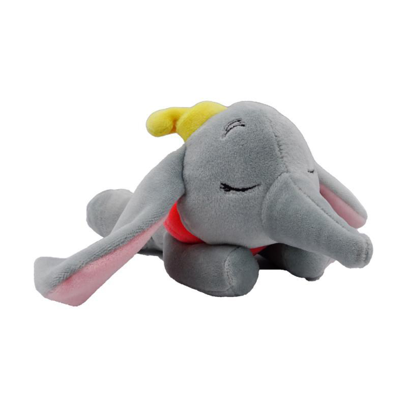 Dumbo-Plüschtier, das liegt. Es ist grau mit großen Ohren und gelbem Hut. Roter Kragen ist sichtbar.