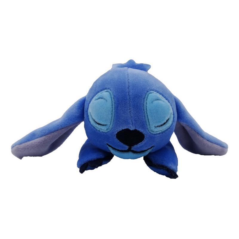 Blaues Stitch-Plüschtier. Stitch liegt mit geschlossenen Augen und Lächeln da.