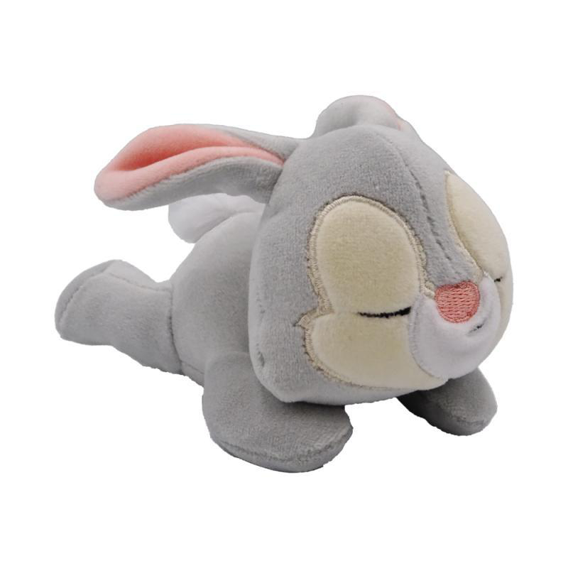 Ein schlafendes Thumper-Plüschtier, grau und weiß, das auf einer weißen Oberfläche liegt.