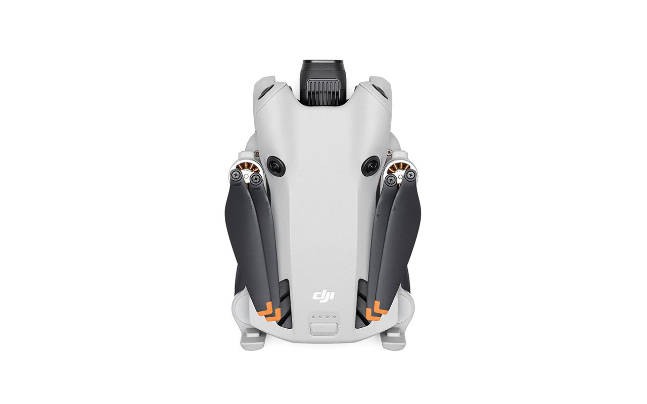 Weiße und graue Drohne mit gefalteten Propellern, orangefarbenen Akzenten und DJI-Logo.