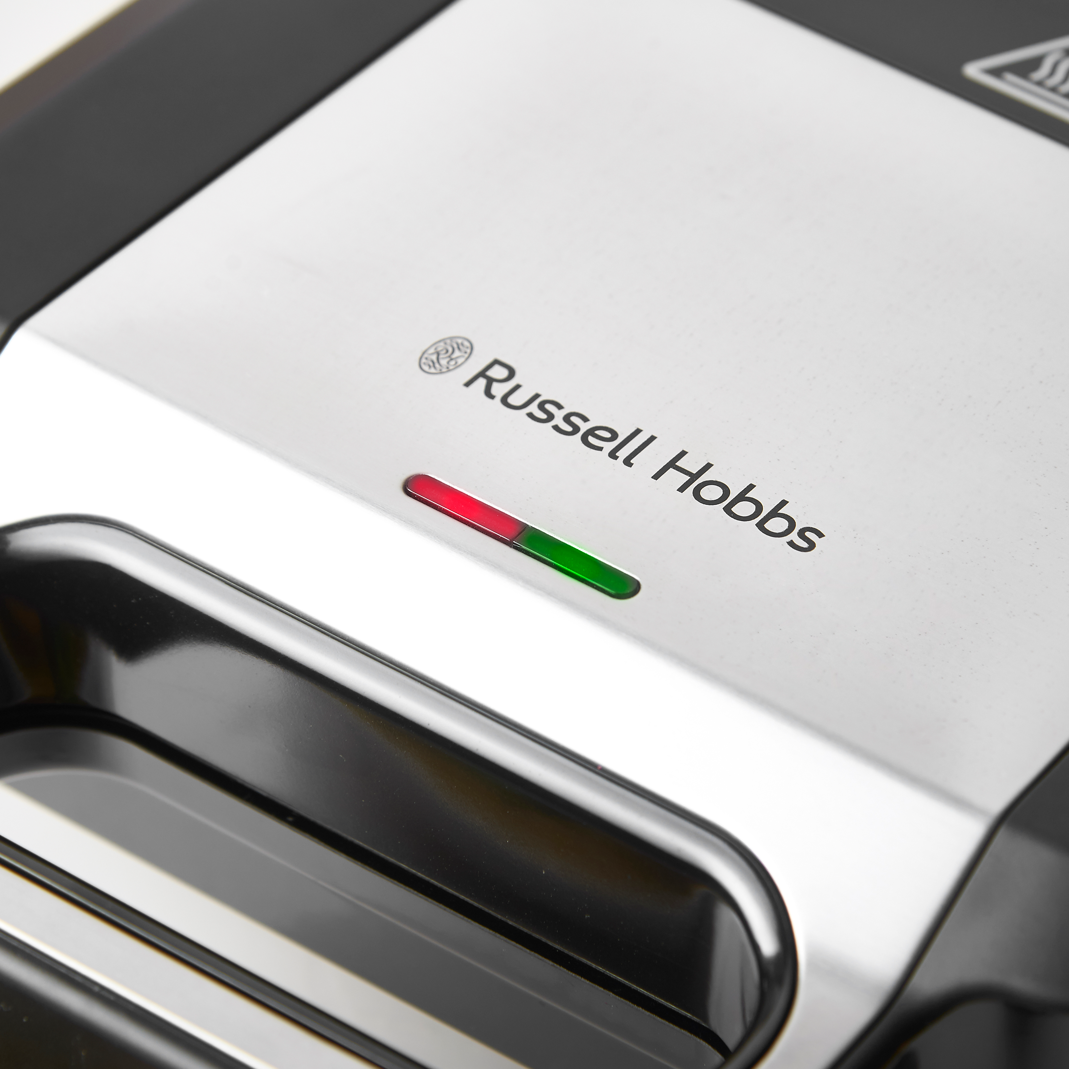 Közelkép egy Russell Hobbs készülékről piros és zöld jelzőfényekkel.