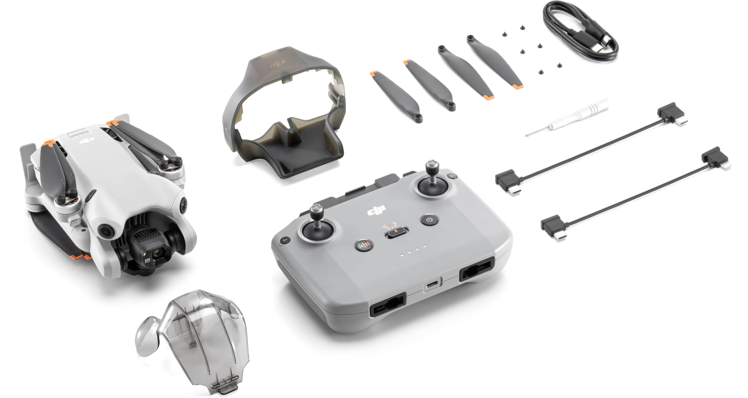 Drone-onderdelen uitgestald: drone, afstandsbediening, propellers, batterij en een schroevendraaier.