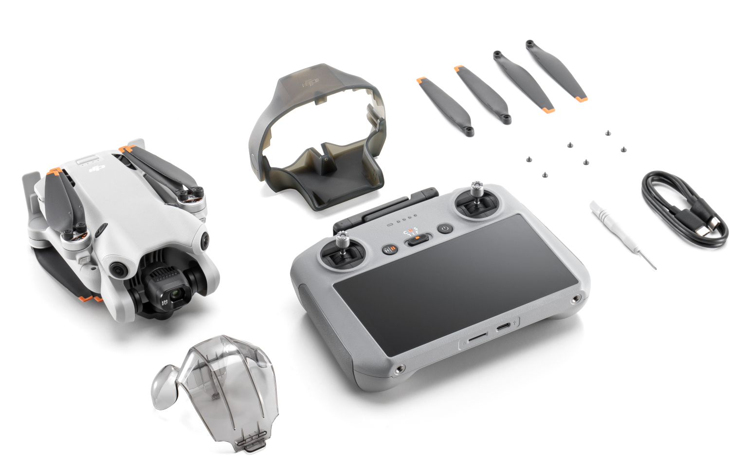 Drone en accessoires. Drone, afstandsbediening, propellers, controllerhoes en een schroevendraaier. Witte achtergrond.