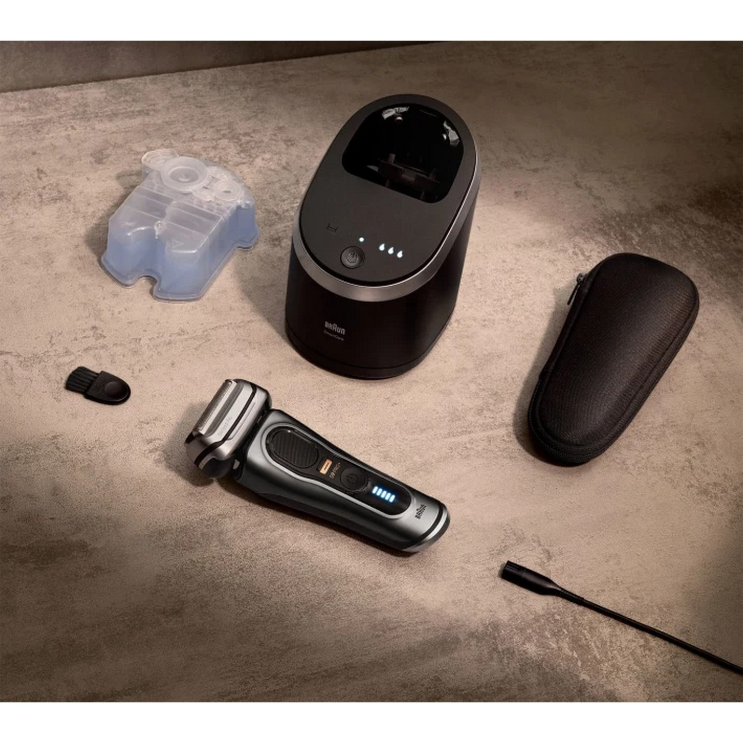 Rasoir Braun Series 9, station de charge, système de nettoyage et étui de voyage sur une surface.