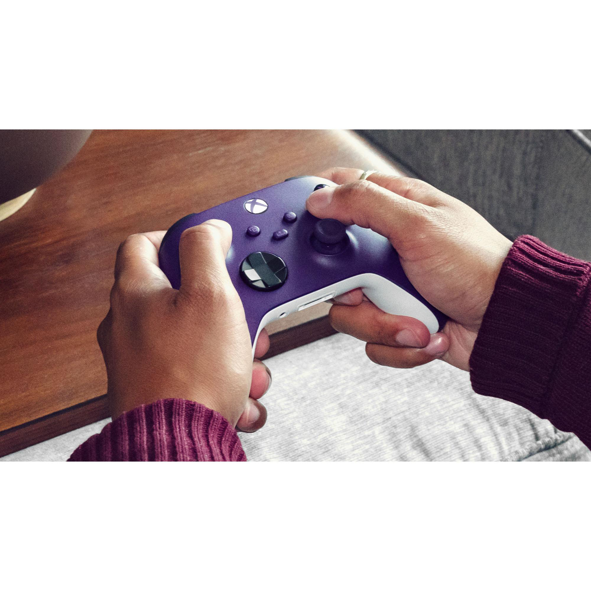 Hände halten einen violetten Xbox-Controller. Tasten und Thumbsticks sind sichtbar.