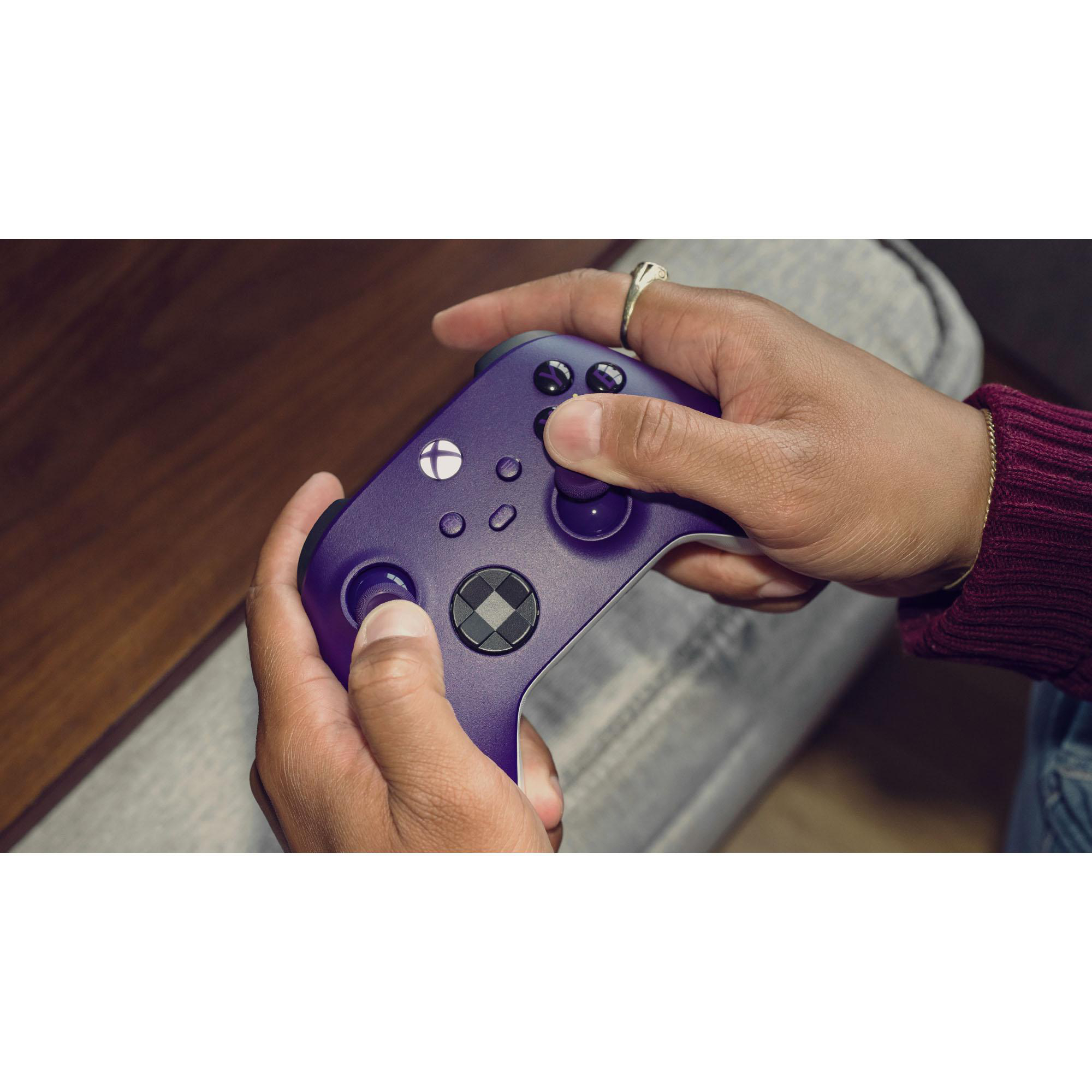 Hände halten einen lila Xbox-Controller mit dem Xbox-Logo in der Mitte.