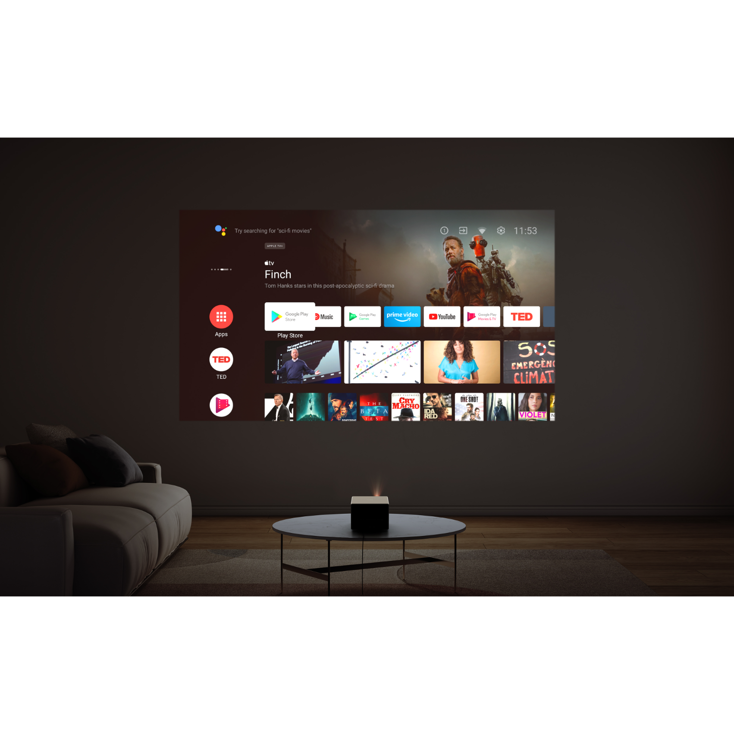 A projector is displaying a screen with a movie selection menu on a white wall in a dark room.