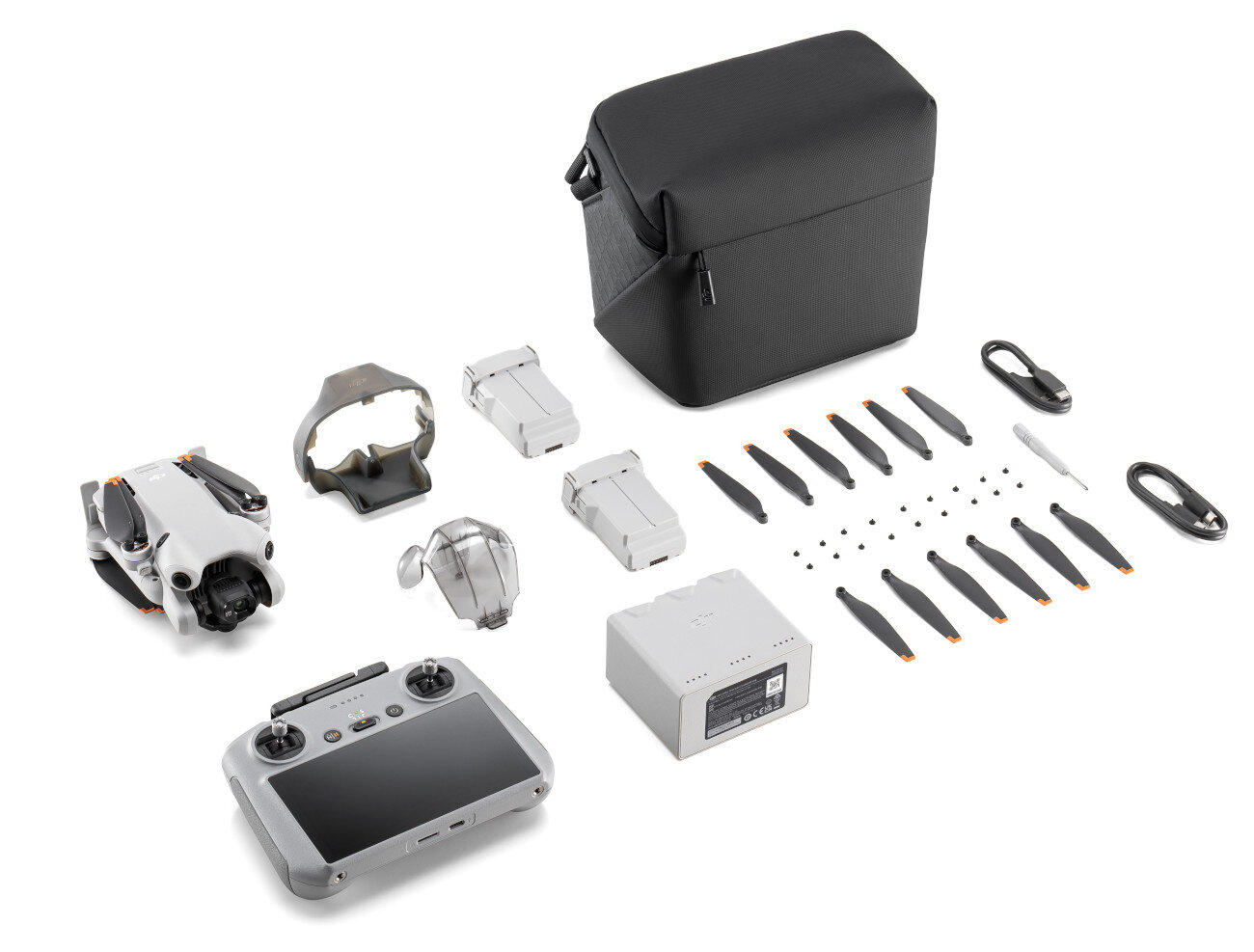 Zestaw drona z akcesoriami. Zawiera drona, pilota, baterie, śmigła i etui.