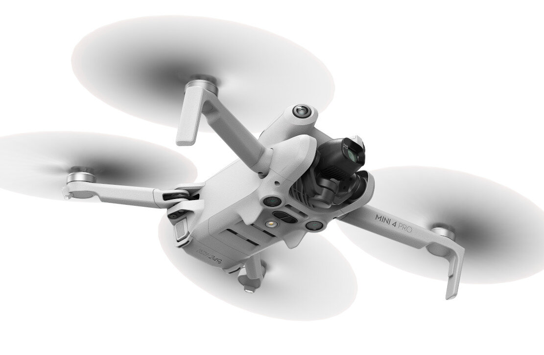 Dron ze śmigłami w powietrzu, ujęcie z góry. Biały dron na białym tle.