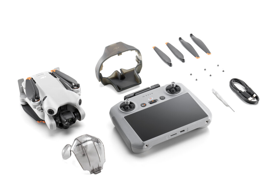 Dron z akcesoriami, w tym pilotem, śmigłami i etui, wszystko na białym tle.