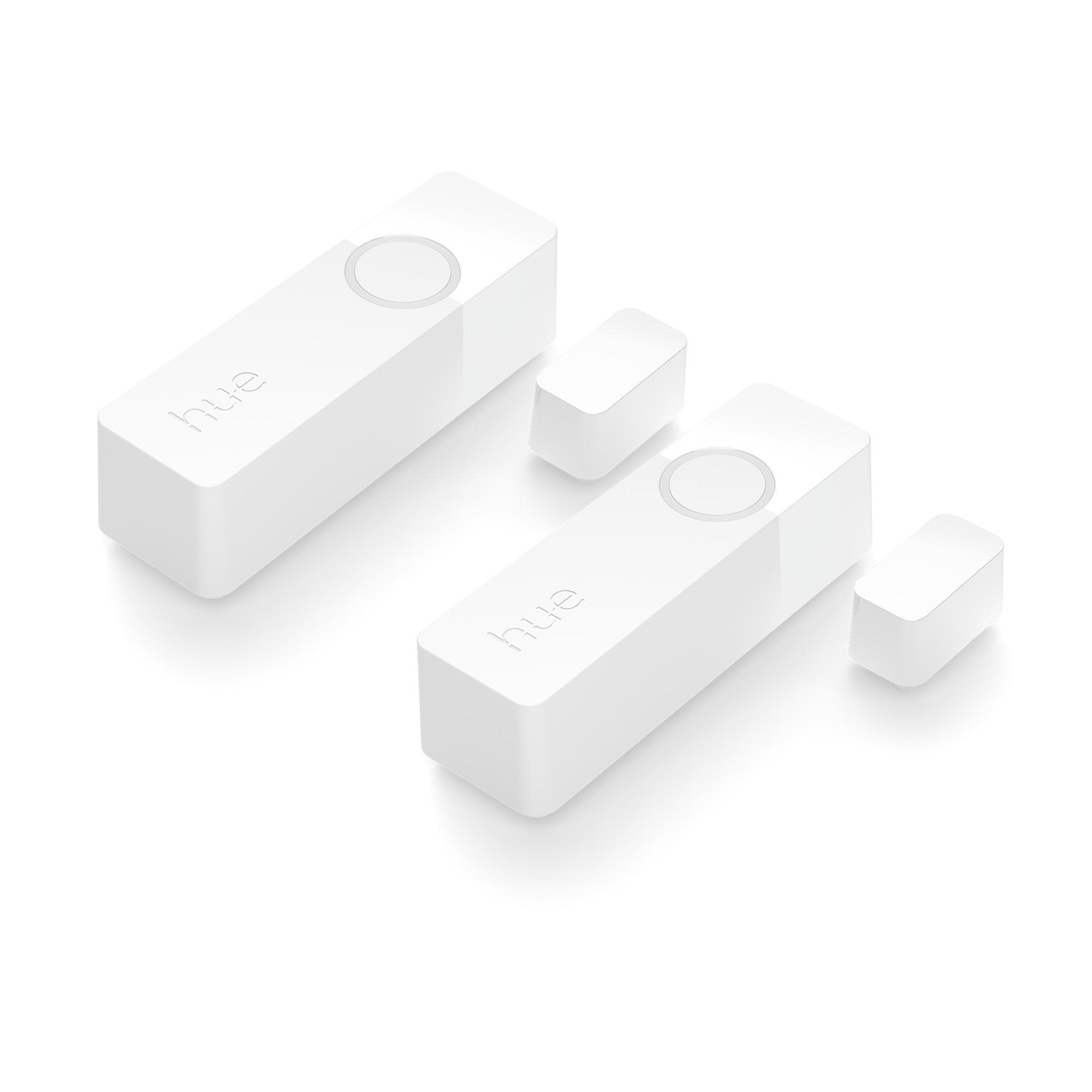 Zwei weiße Smart-Home-Tasten mit dem Wort „hue“. Zwei kleine weiße Zubehörteile.