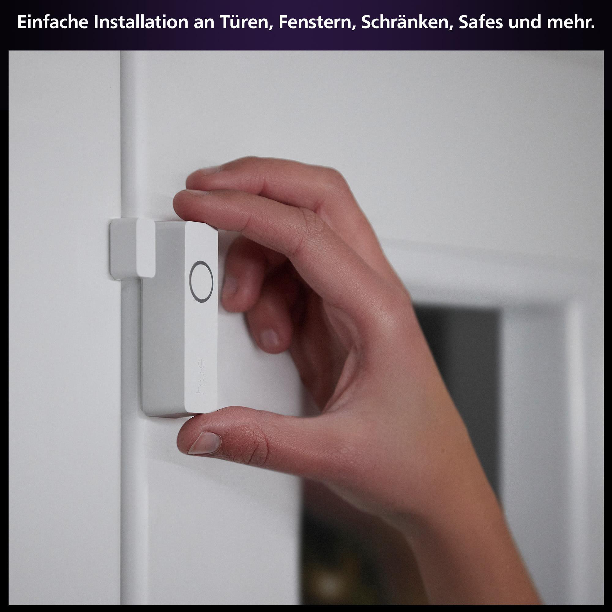 Eine Hand installiert ein weißes Smart-Home-Gerät an einem Türrahmen.