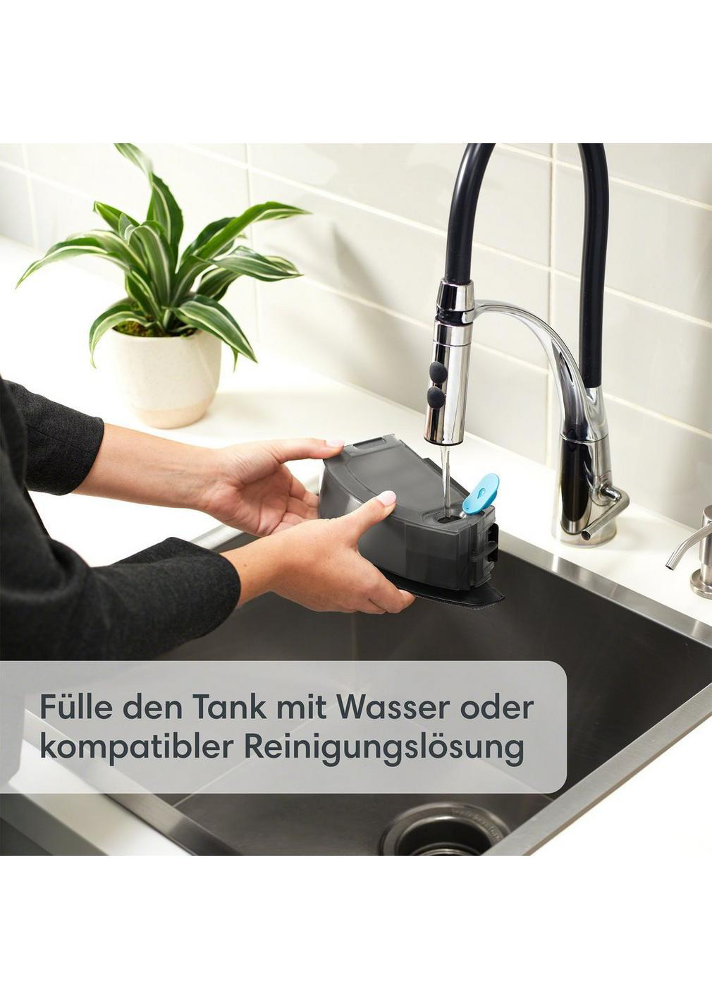 Eine Person, die einen Wassertank in einem Waschbecken hält, Text auf Deutsch.