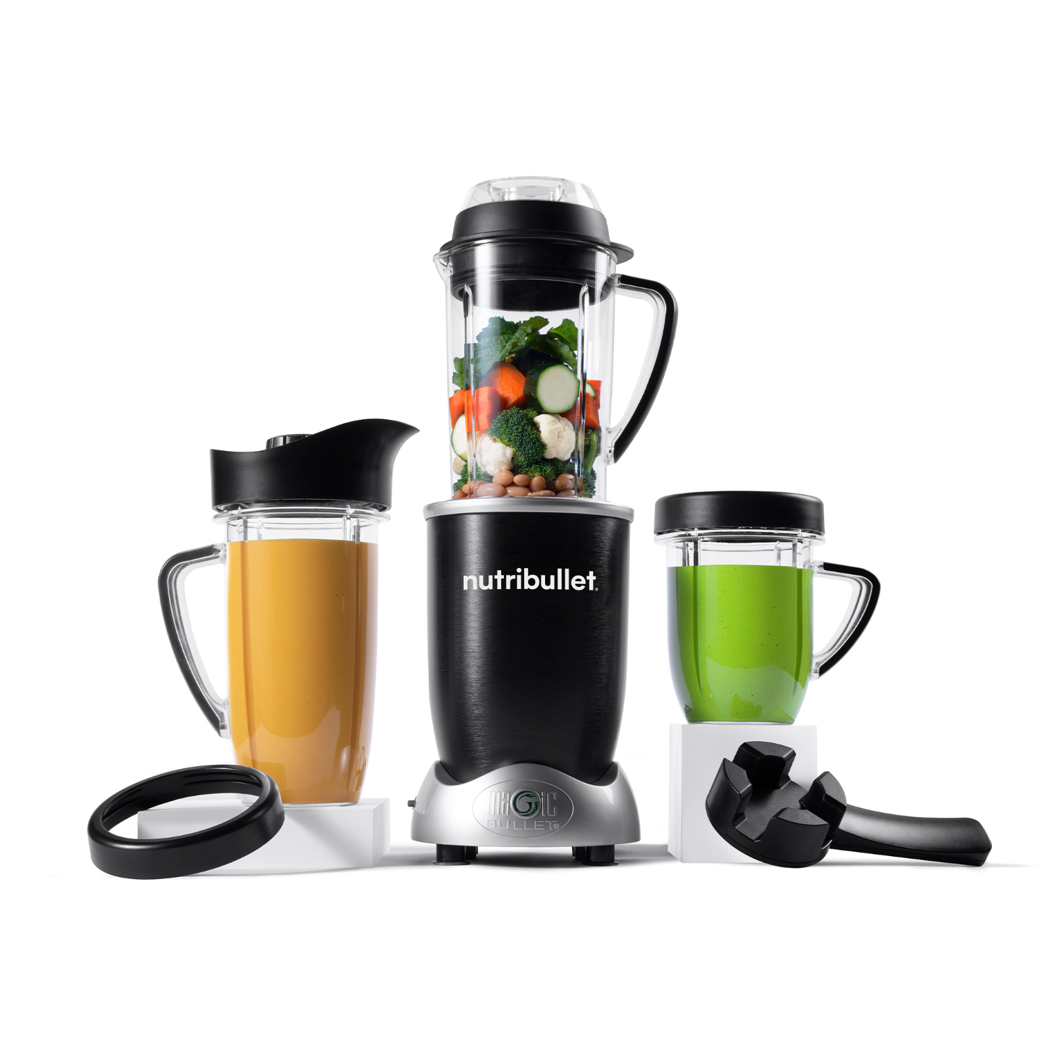 A Nutribullet blender set with three cups, one with orange liquid and one with green.