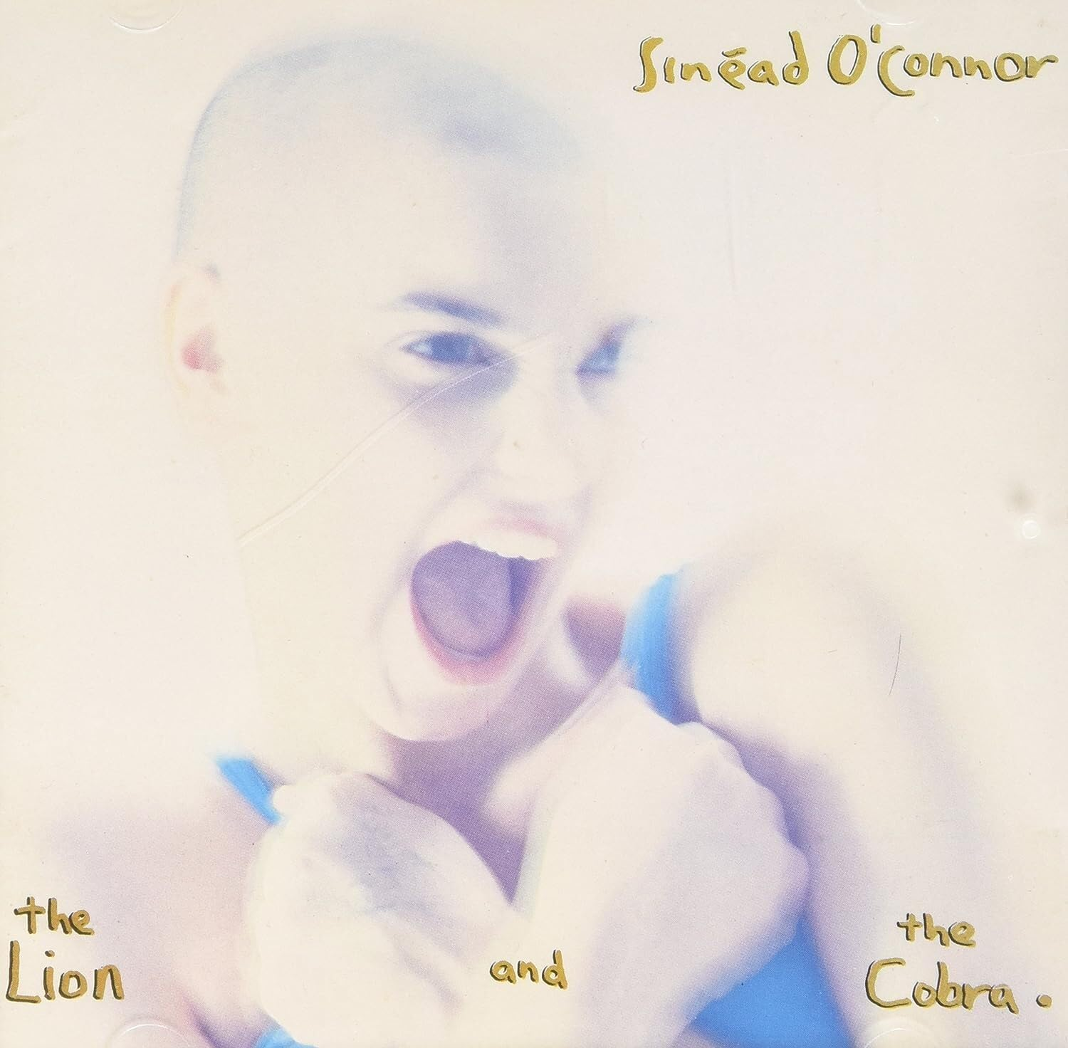 Sinead O'Connor az albumon, nyitott szájjal sikít. 'The Lion and the Cobra' szöveg.
