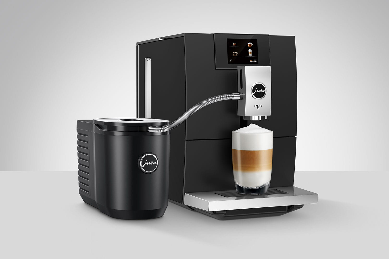 Schwarze Jura-Kaffeemaschine mit Milchbehälter und Glas Latte.