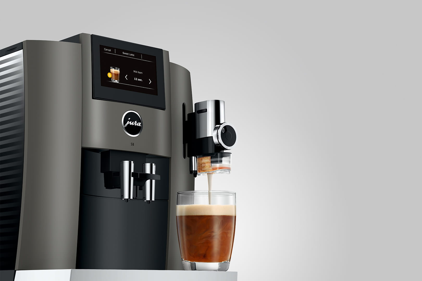 Macchina da caffè che eroga caffè in un bicchiere. Schermo mostra un messaggio.