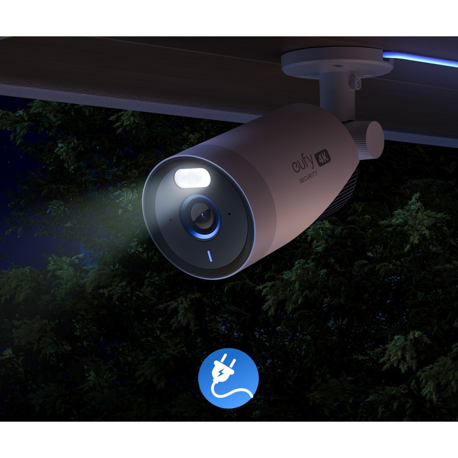 White security camera with a lit-up lens, mounted on the ceiling.