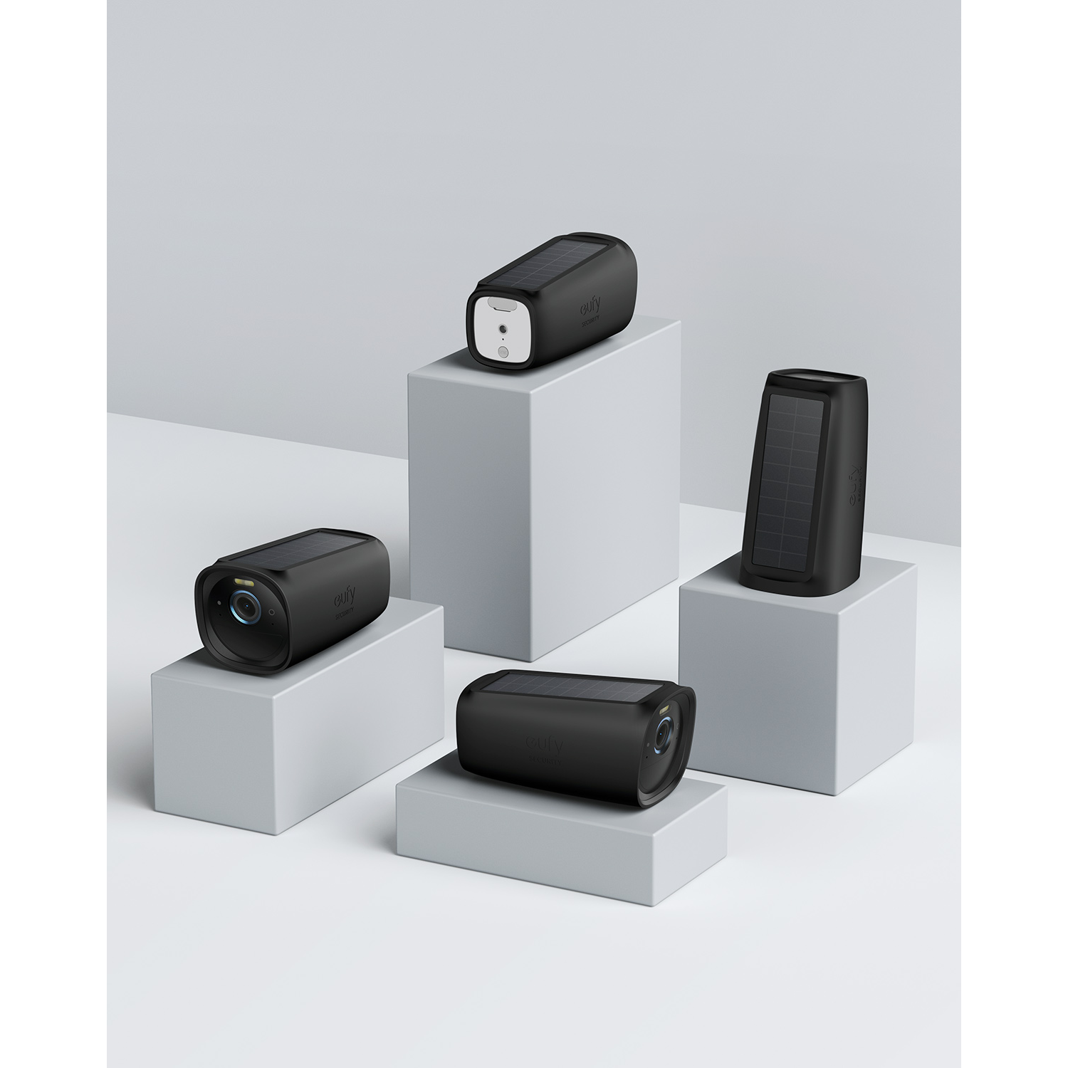 Several black security cameras on gray blocks.