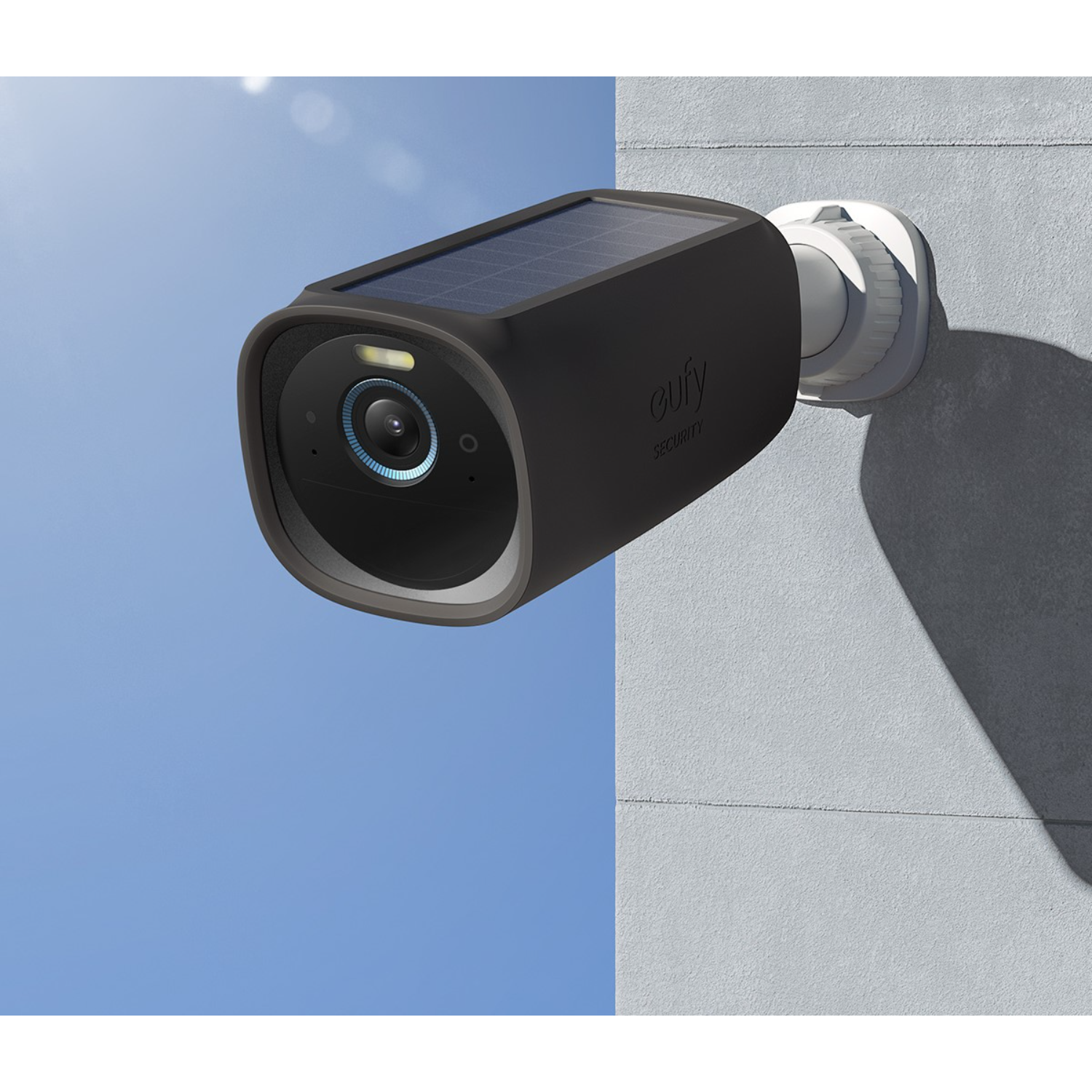 A black Eufy security camera mounted on a white surface against a blue sky.