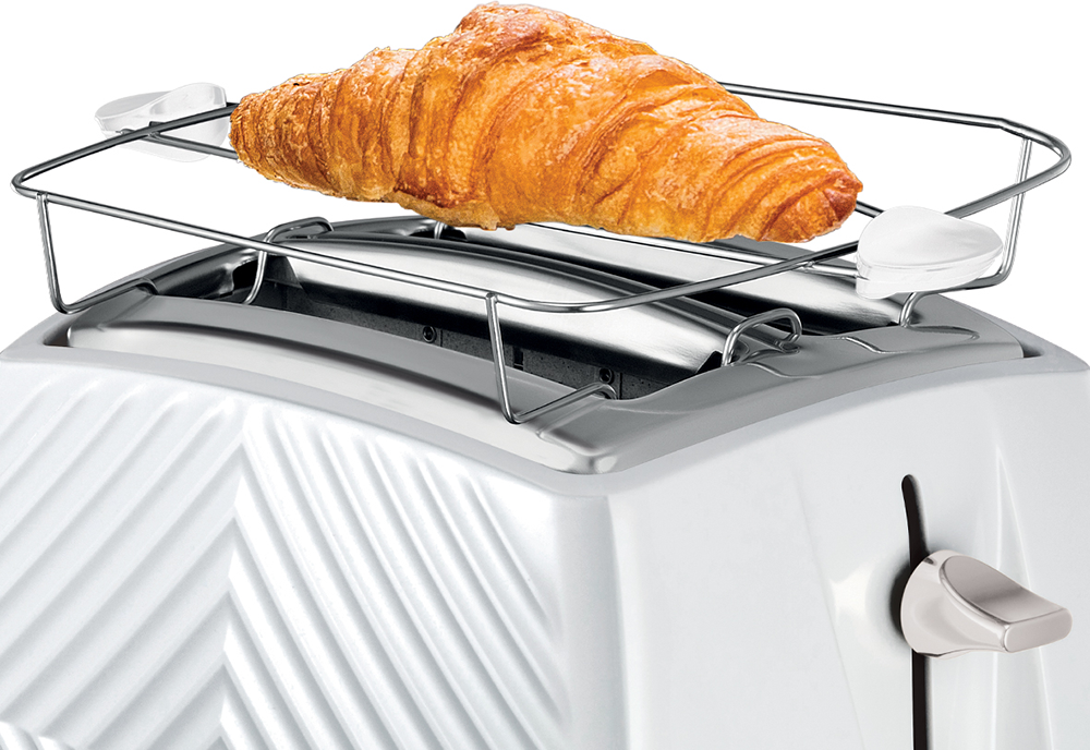 Pirító egy croissant-val a rácson. Fehér pirító dekoratív mintával.