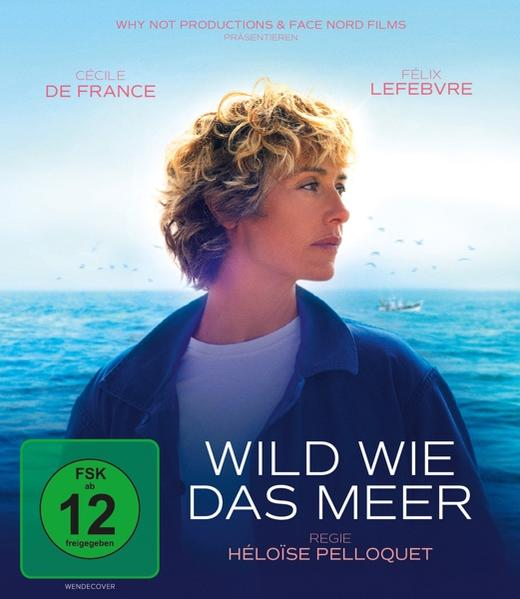 Eine Frau mit kurzen, hellen Haaren blickt nach rechts, das Meer im Hintergrund.