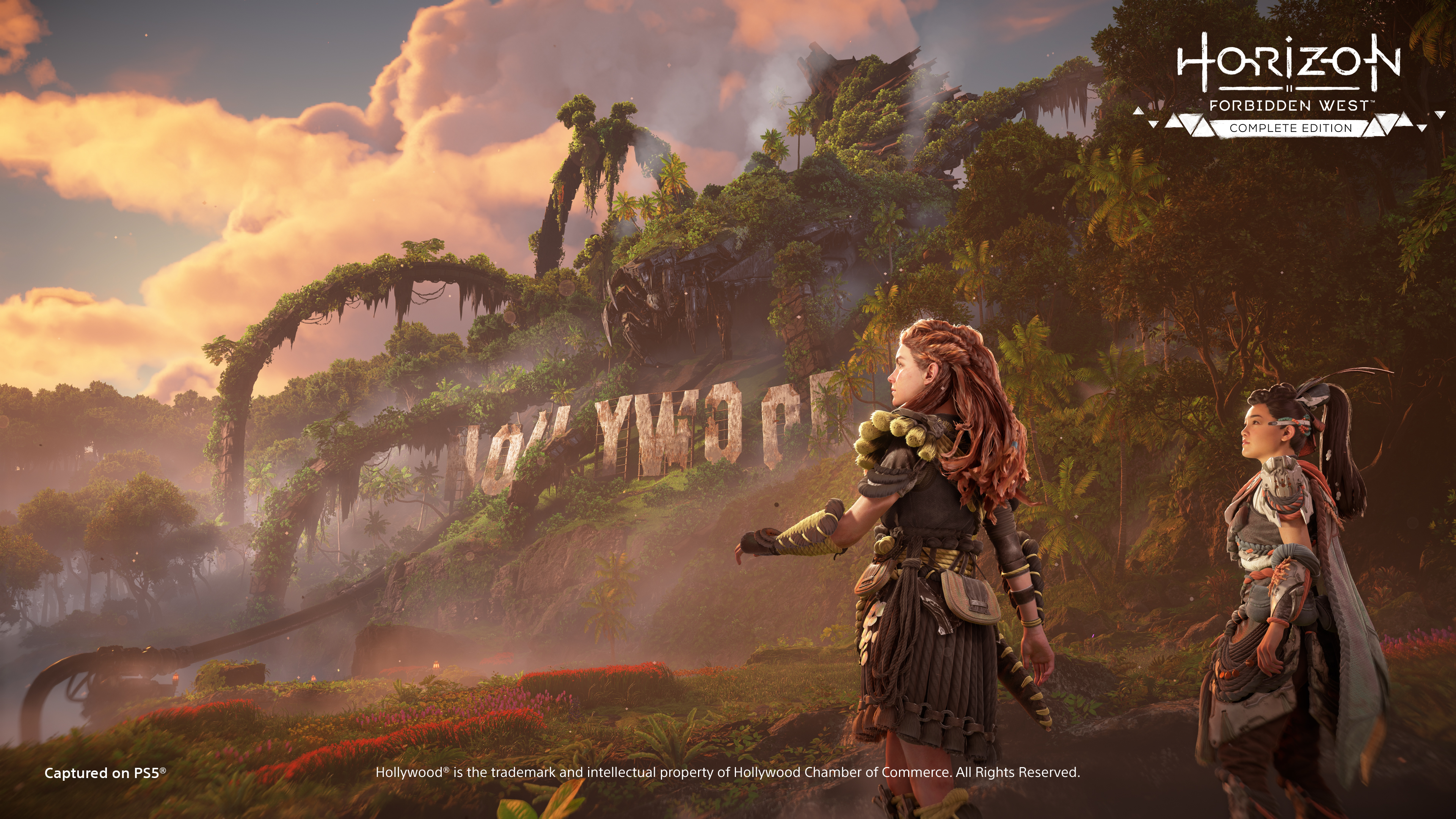 Zwei Frauen in einer Spielszene mit dem Hollywood-Zeichen im Hintergrund, Sonnenuntergang.