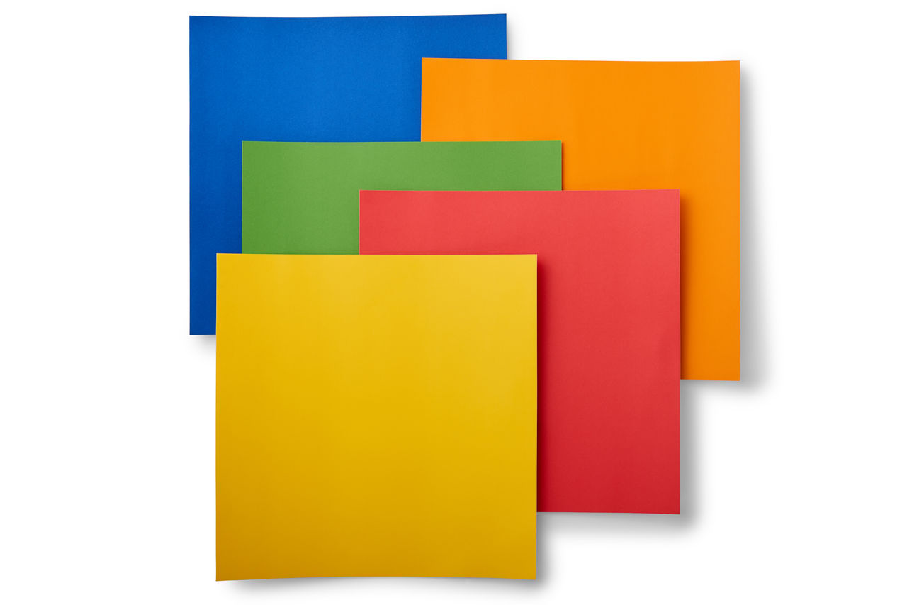 Fünf bunte Papierbögen sind gestapelt. Die Farben sind blau, grün, gelb, rot und orange.