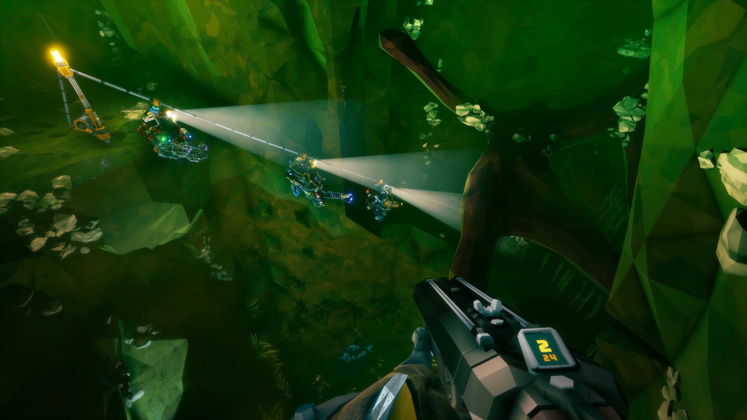 Vue à la première personne dans une grotte verte. Joueurs avec des lumières explorent. Armes futuristes visibles.