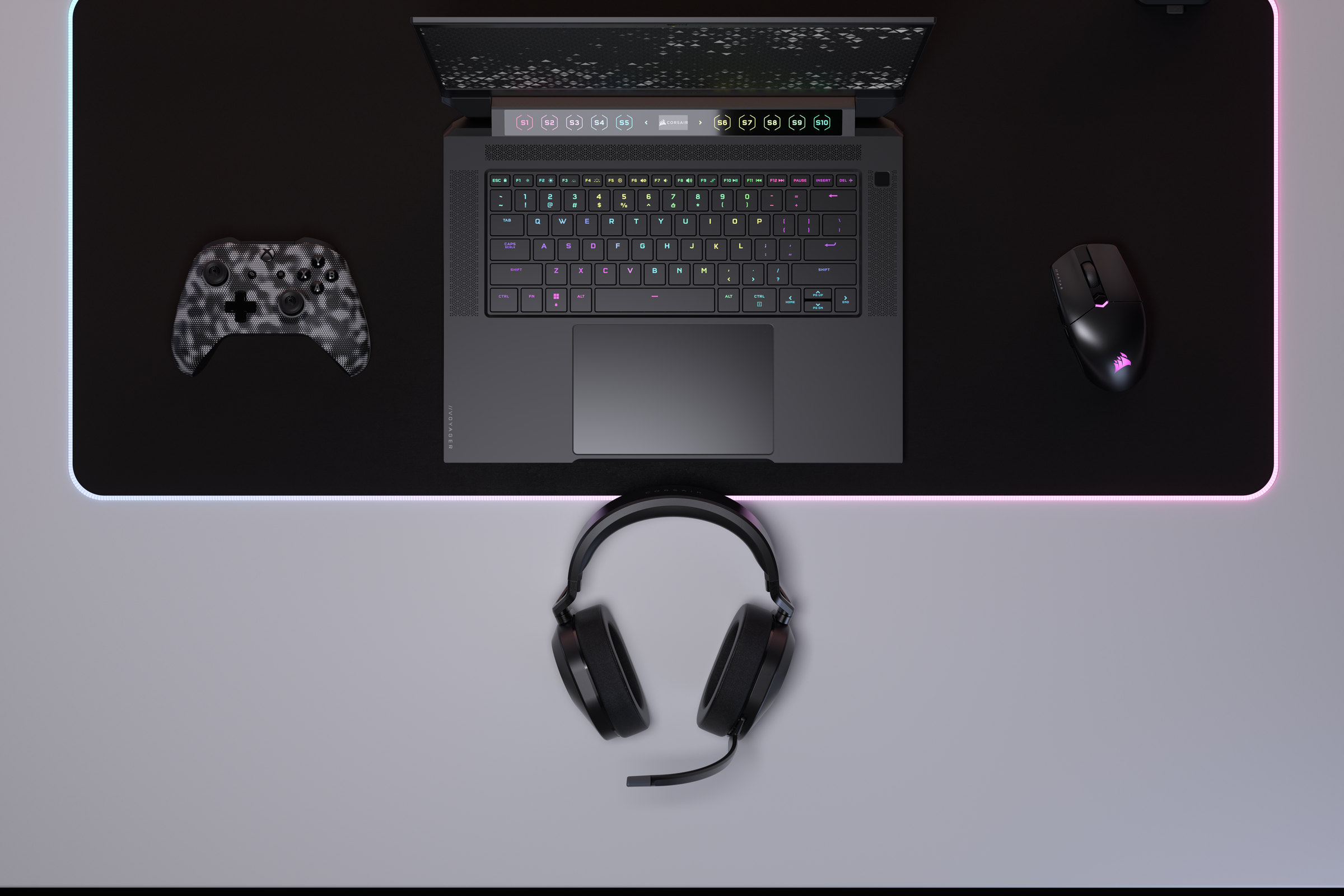 Configuration de jeu : ordinateur portable, manette, souris et casque sur un bureau.