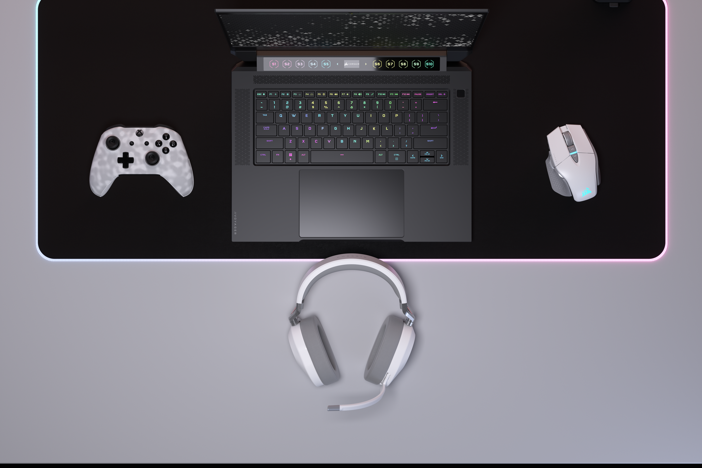 Gaming-Setup: Laptop, Maus, Headset und Gamepad. Alles auf einer schwarz-grauen Oberfläche.
