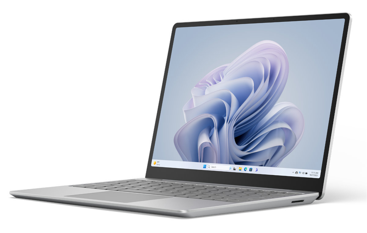 Srebrny laptop z interfejsem Windows, otwarty na białej powierzchni. Ekran wyświetla interfejs.