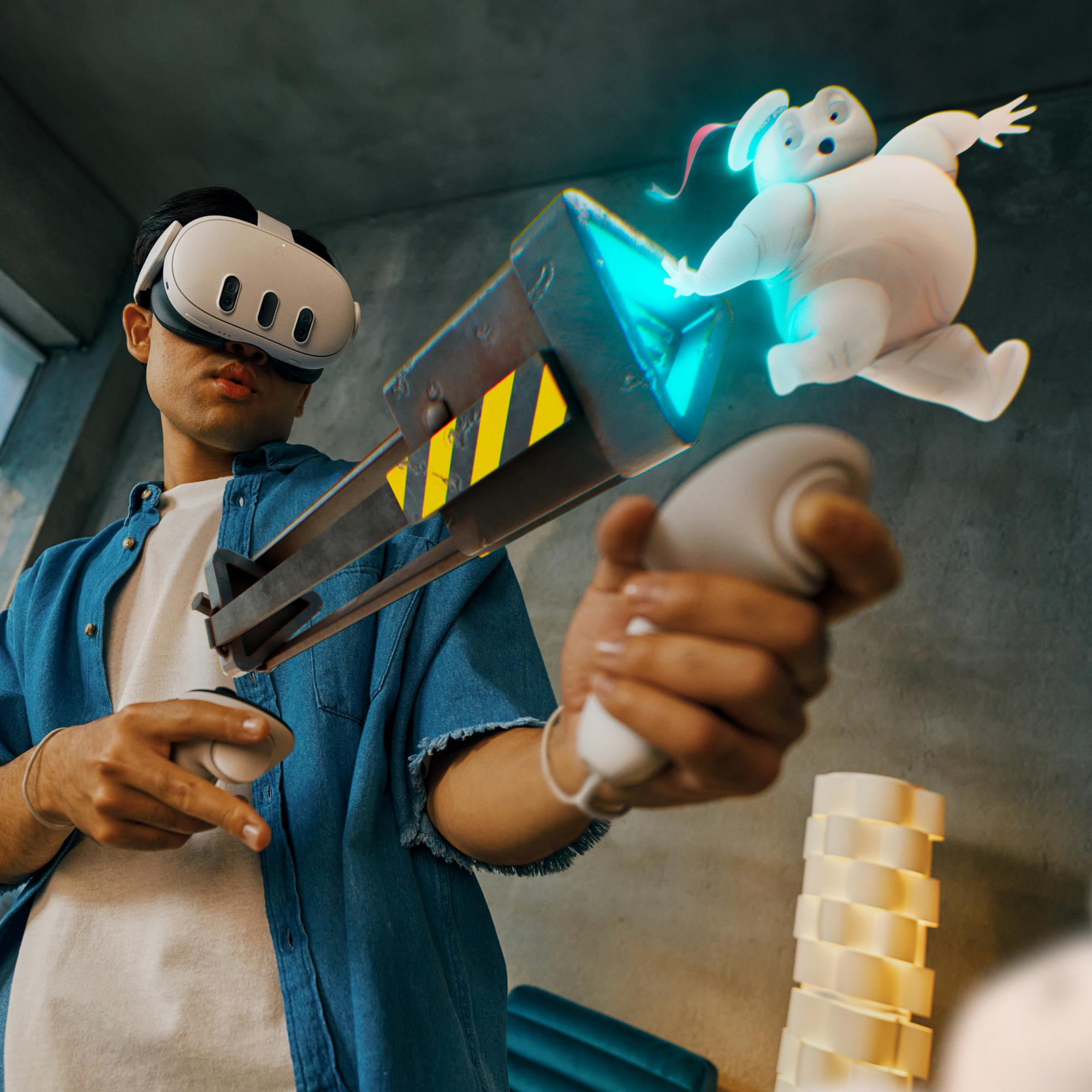 Mann mit VR-Headset, hält eine Waffe und einen Controller. Ghostbuster-Charakter schwebt.