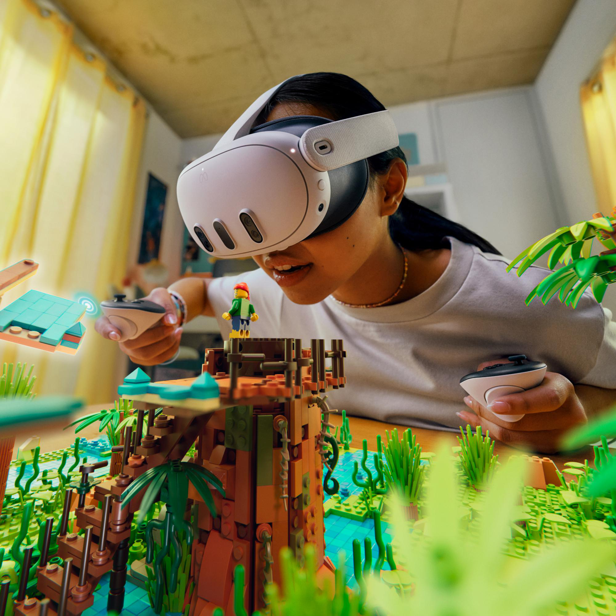 Eine Person mit VR-Headset spielt mit Lego in einem hellen Raum. Lego-Strukturen und Controller sind sichtbar.