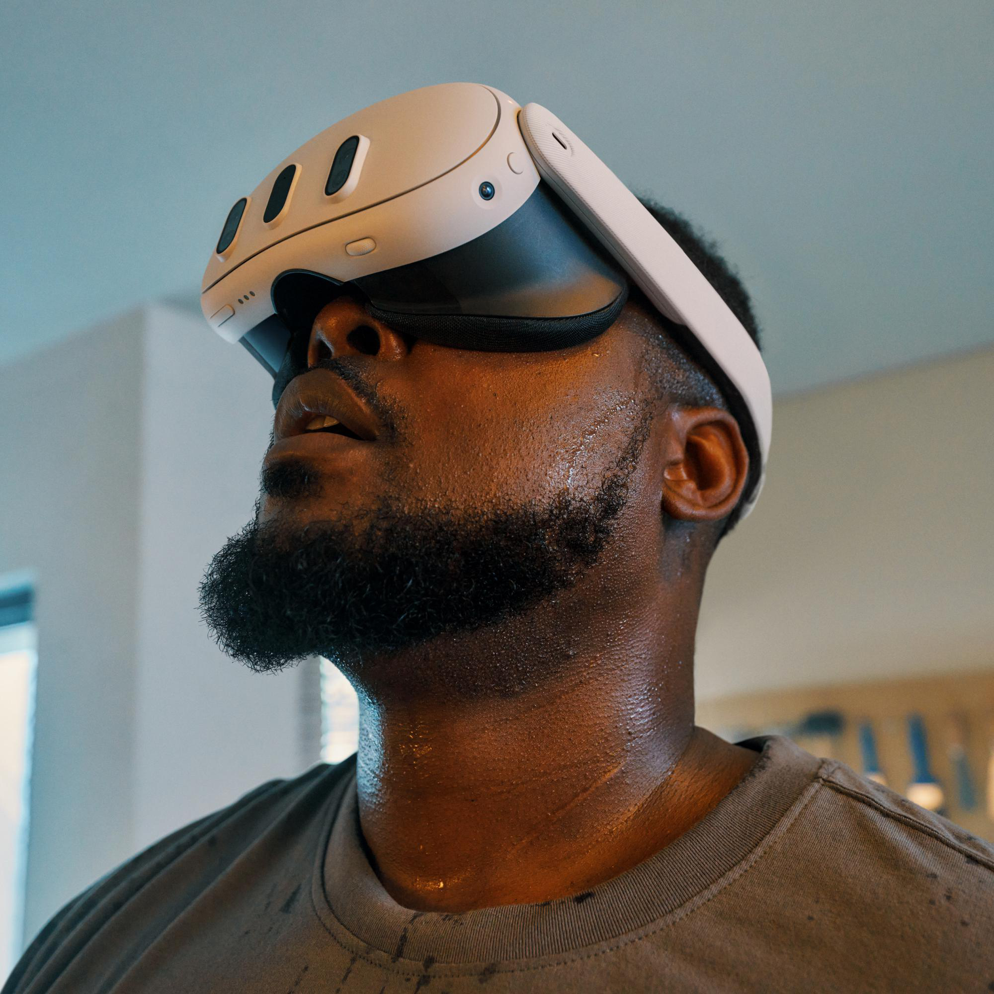Mann mit VR-Headset. Er schaut nach oben. Das Headset ist weiß, und er hat einen Bart.