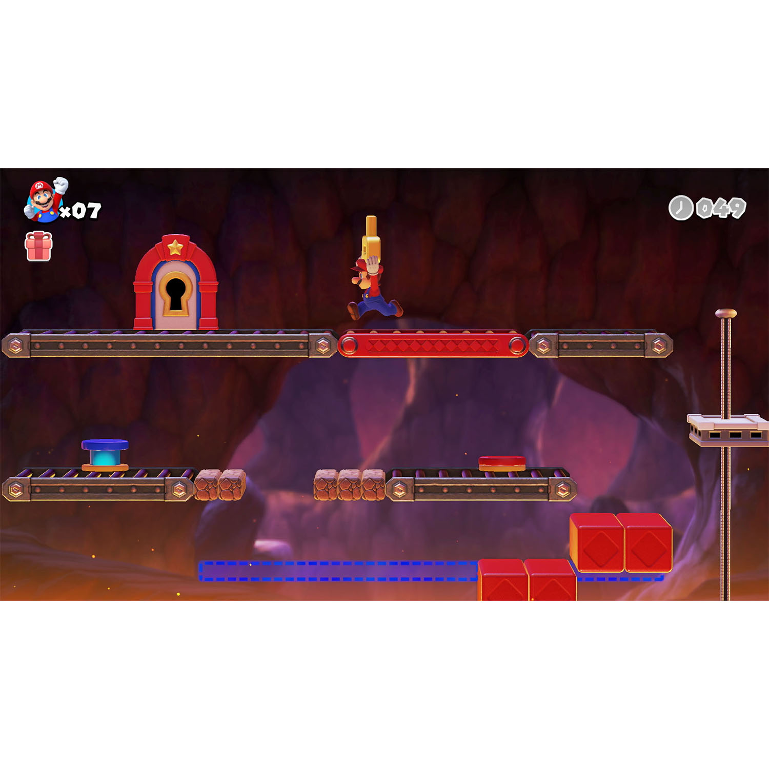 Una scena di videogioco. Un personaggio salta sulle piattaforme in un ambiente simile a una grotta. Elementi rossi e blu sono visibili.