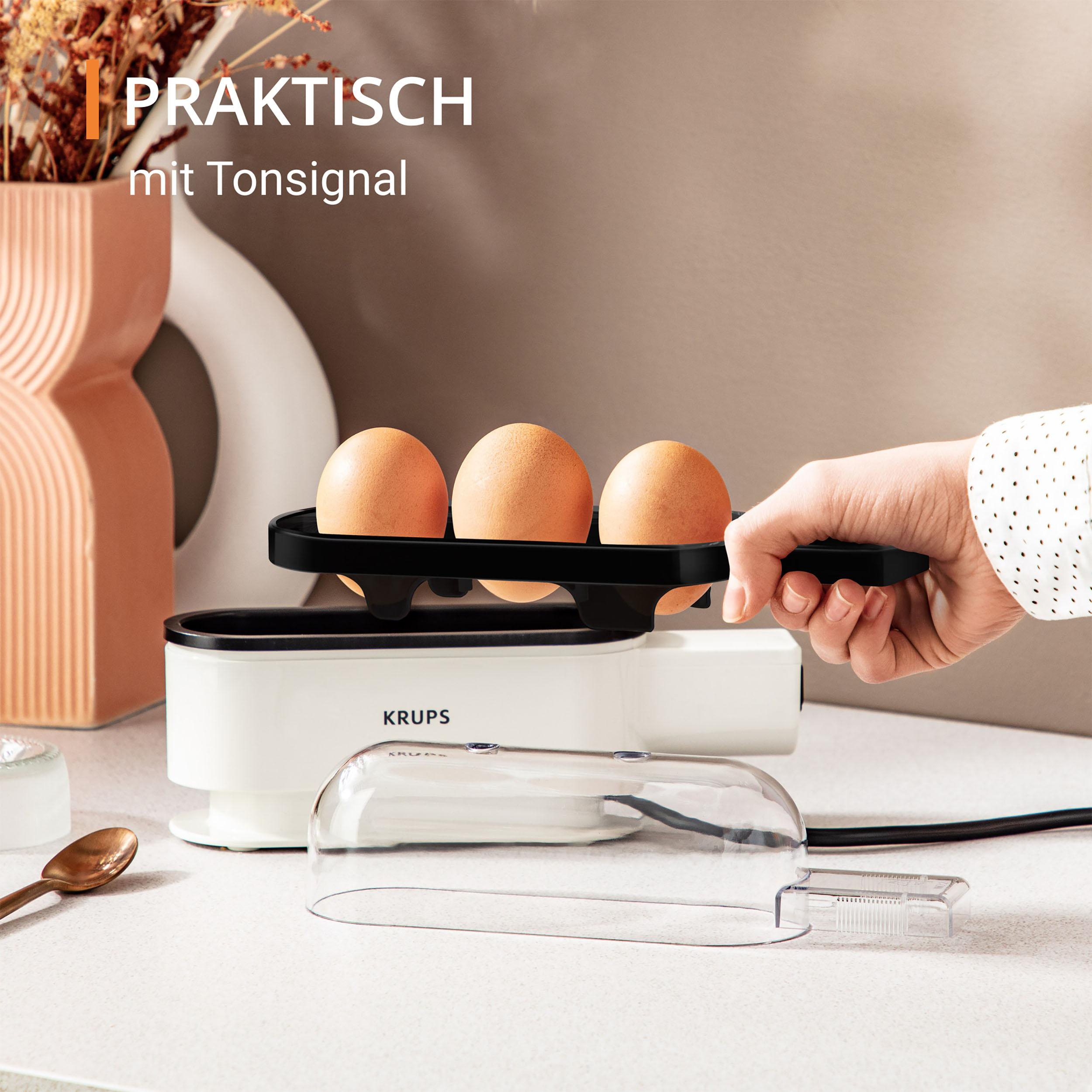 Eine Hand hält einen weiß-grünen Stabmixer mit Knöpfen.