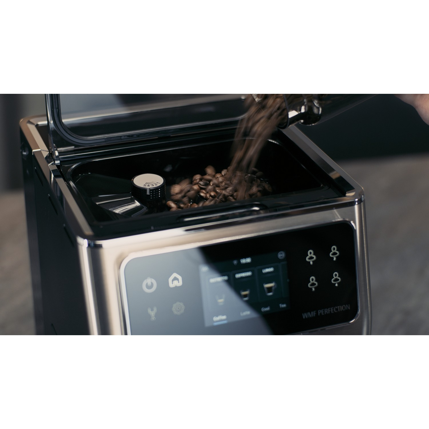 Coffee beans pouring into a coffee machine with a touchscreen and buttons.