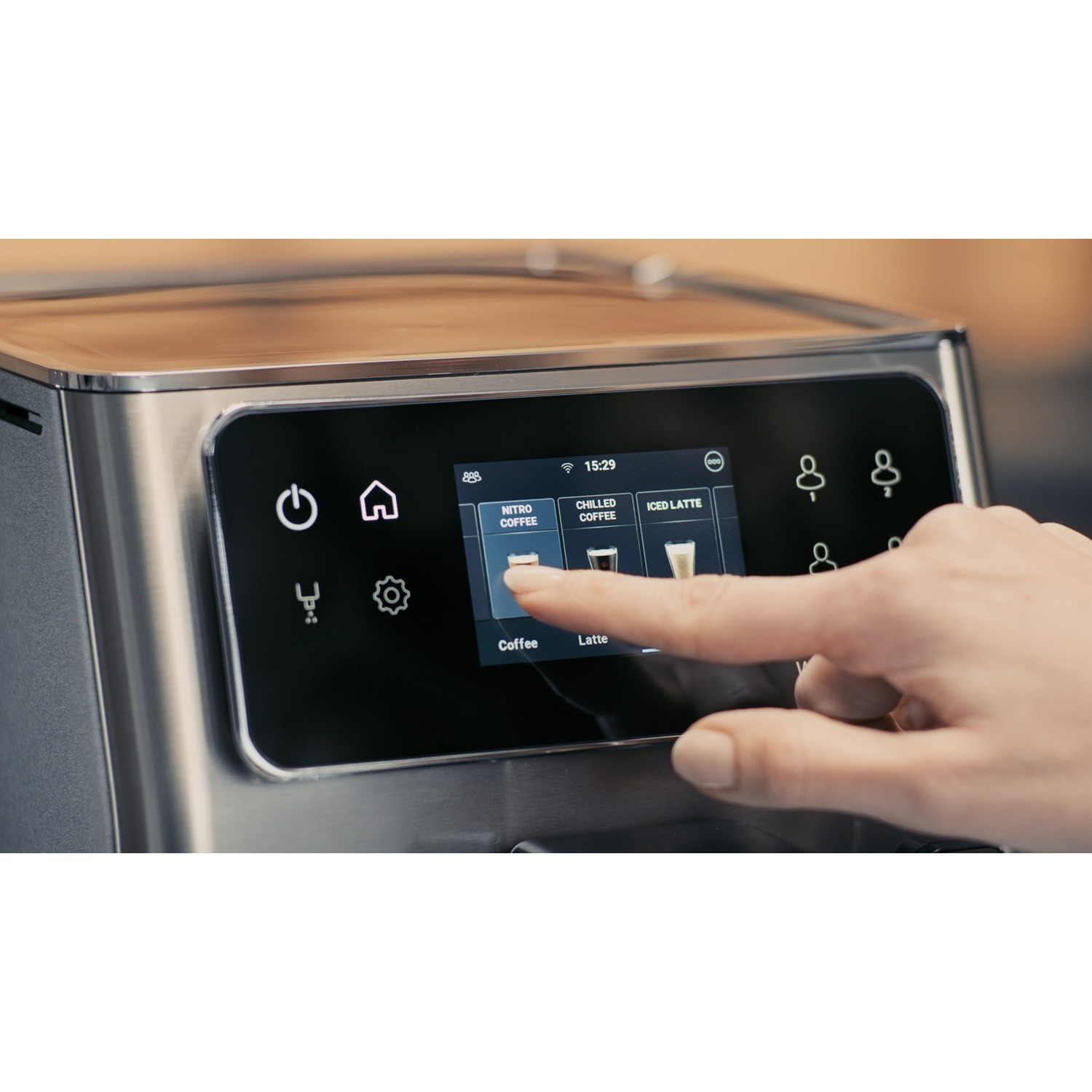 Close-up of a hand touching a coffee machine's touchscreen, selecting coffee options.