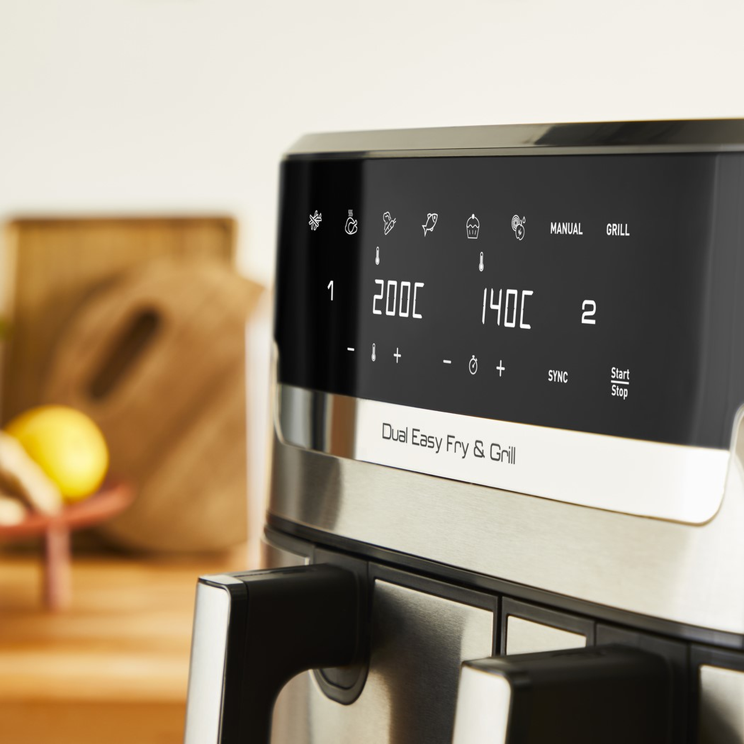 Close-up van het bedieningspaneel van een airfryer met instellingen. 200C en 140C zijn zichtbaar, met iconen en tekst.