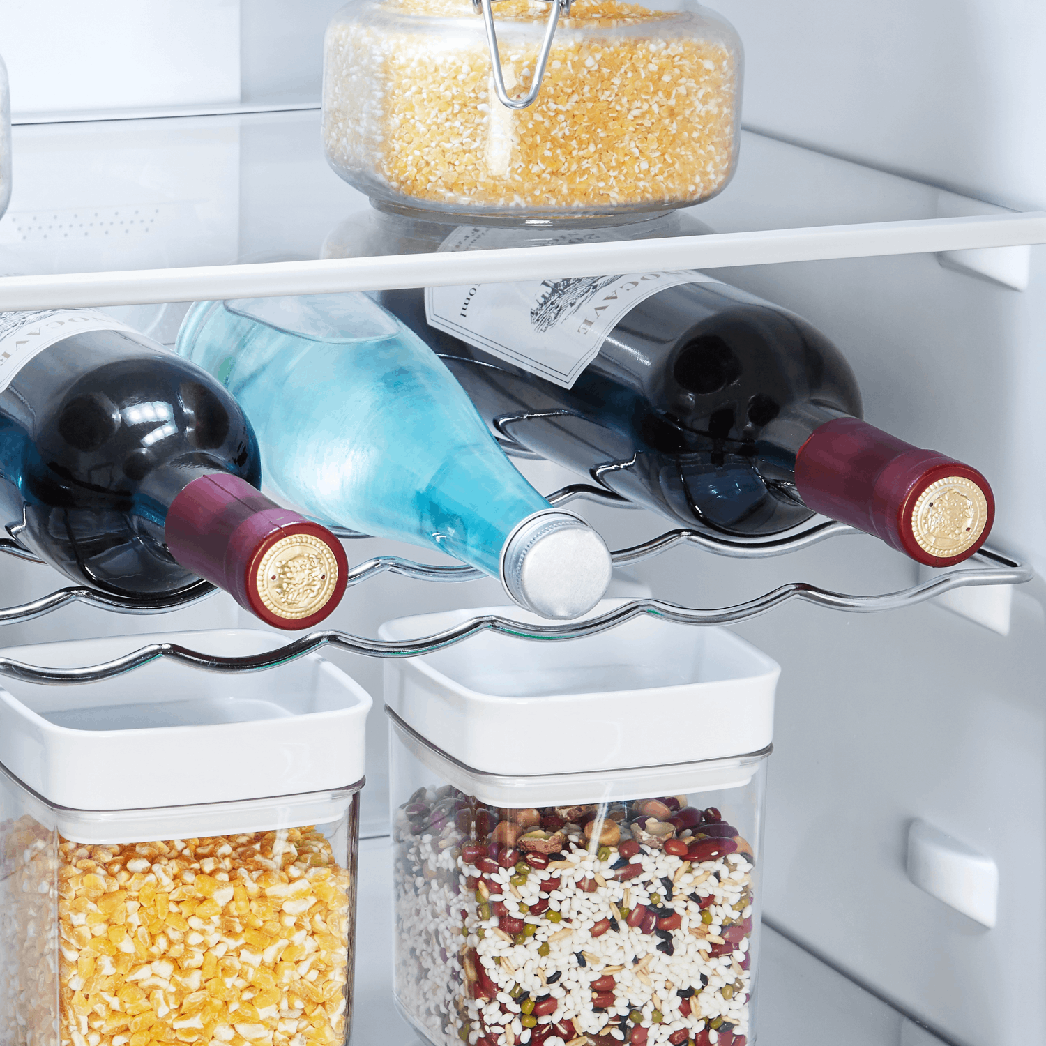 Interior de refrigerador con botellas de vino y frascos de comida.